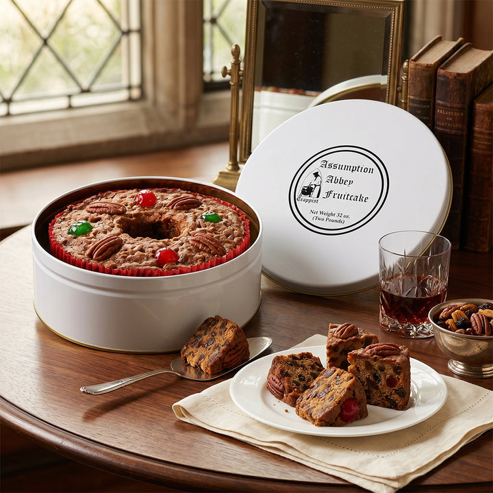 Assumption Abbey Fruitcake in gift tin with packaging on a wooden table.
